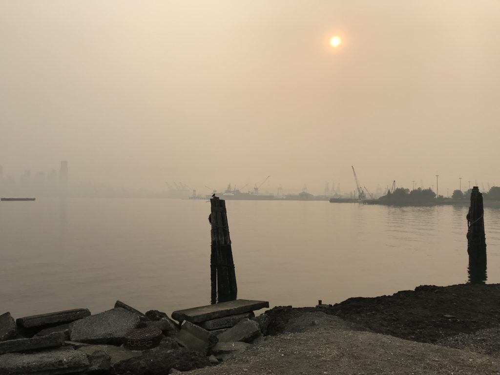 Image of Port of Seattle and Downtown Seattle skyline from West Seattle in August 2018. Thick smoke from wildfires obscures the view.