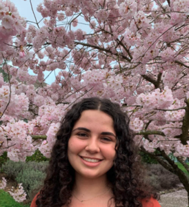 Talia Kertsman in front of cherry blossom trees