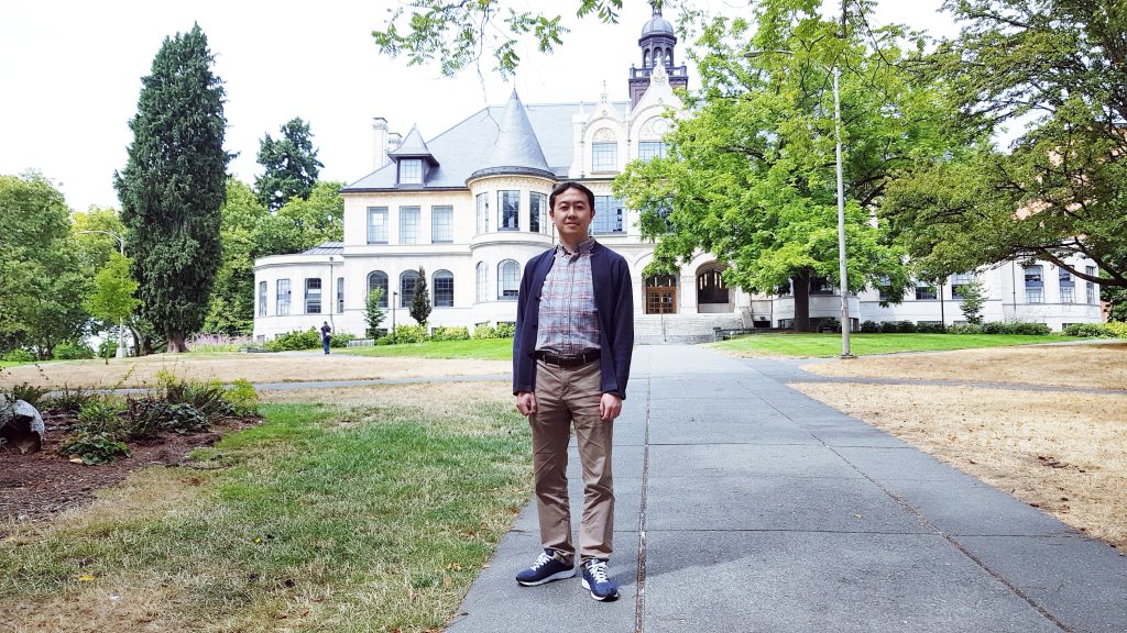 Chungho Kim standing in front of Denny Hall