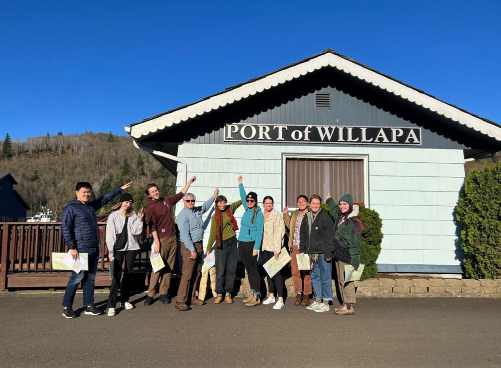 A group of people standing in front of a building with a sign that says ' Port of Willapa'