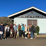 A group of people standing in front of a building with a sign that says ' Port of Willapa'