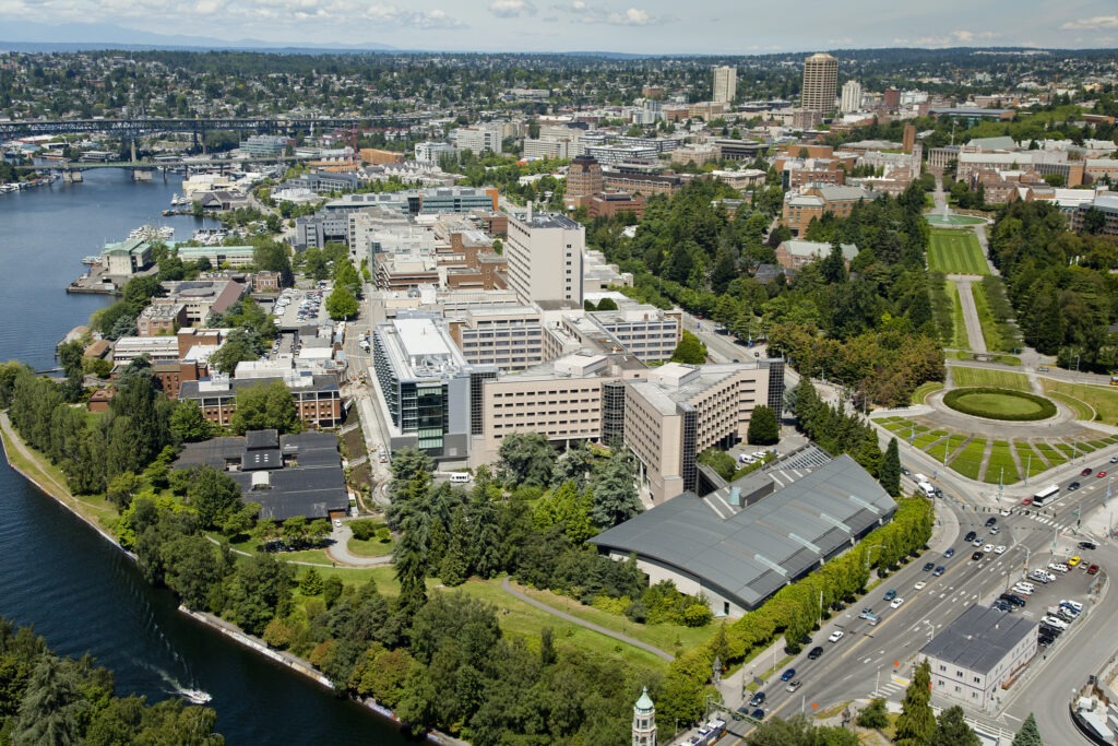 Aerial photo of the UW Seattle Campus, featuring intersecting streets, buildings, bridges, and landscape architecture of campus by Drumheller Fountain